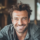 Homme souriant en intérieur.